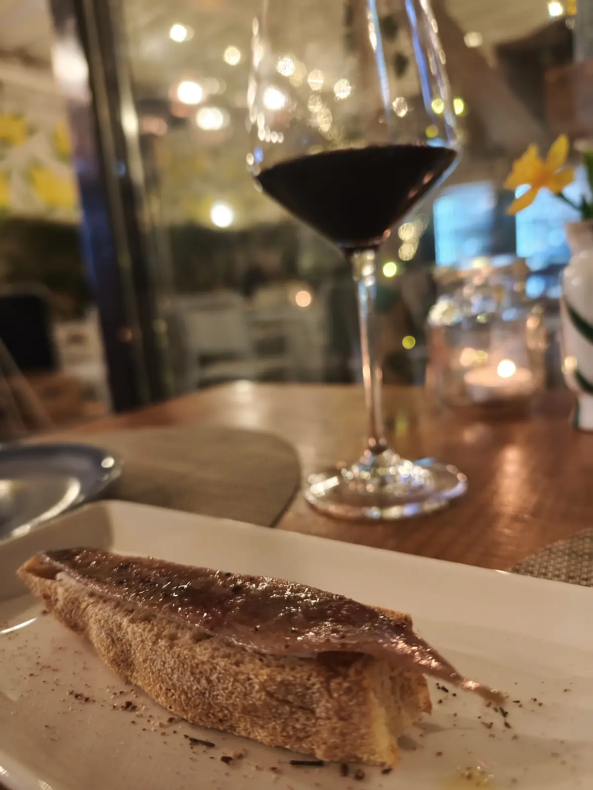Anchovy montadito with a glass of red wine